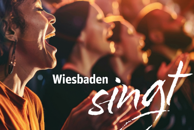 Veranstaltungsbild Menschen die singen mit dem Schriftzug "Wiesbaden singt"