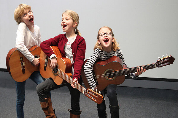 Drei Kinder mit Gitarren